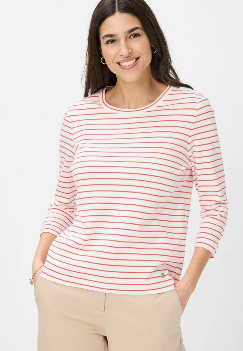 Langärmliges T-Shirt mit Rundhalsausschnitt in Weiß mit roten horizontalen Streifen. Weiches Material; mit einem kleinen Logodetail am Saum.