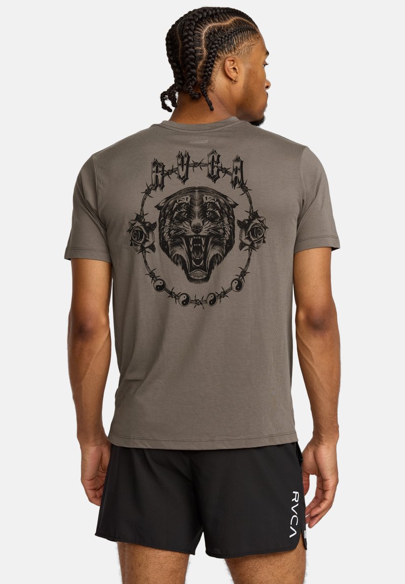 T-shirt grigio con una grande grafica nera di una tigre ruggente circondata da rose e fili spinati. Maniche corte, materiale cotone.