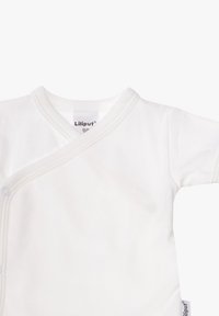 White cotton baby wrap shirt with a V-neck and snap closures, featuring soft texture and minimalistic design with subtle stitching.