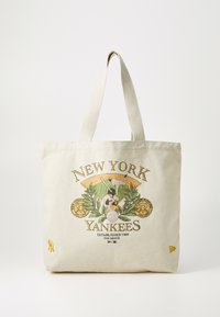 Beżowa torba na ramię z płótna z kolorową grafiką New York Yankees w stylu baseballowym, z zielonymi liśćmi i żółtymi akcentami. Podwójne uchwyty.