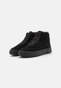 Czarne zamszowe sneakersy typu high-top z teksturowaną gumową podeszwą, wyposażone w czarne sznurówki i lekko podwyższoną platformę. Brak wyróżniających się wzorów lub akcentów.