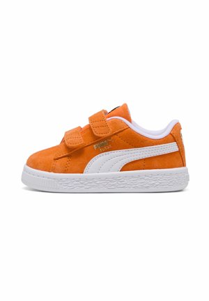 Baskets en daim orange avec bande blanche Puma, doubles bandes velcro, et semelle blanche texturée montrées de profil sur fond blanc.