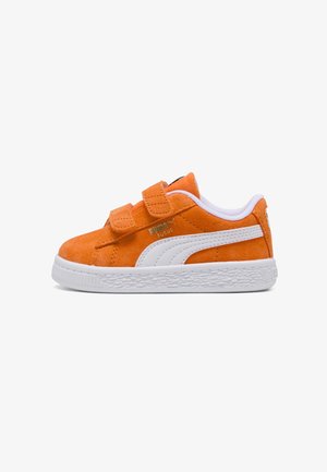 Oranger Veloursleder-Sneaker mit weißem Puma-Streifen, doppeltem Klettverschluss und strukturierter weißer Sohle, von der Seite vor weißem Hintergrund gezeigt.