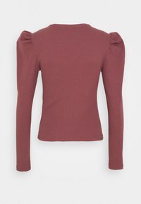 Långärmad topp i dammros med ribbad struktur, figurnära design och puffade axlar. Ensfärgad, mjuk tyg och rund halsringning.