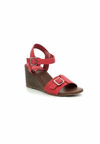 Sandalias cuñas rojas con una parte superior sintética suave, correa ajustable en el tobillo y una suela de plataforma marrón texturizada con líneas horizontales.