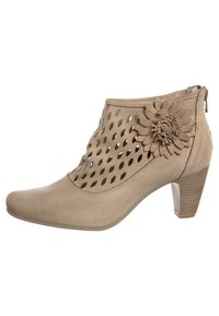 Botas de tobillo beige con un diseño recortado, un acento de flor texturizada y un tacón bloque. Material suave con un cierre de cremallera en la parte posterior.