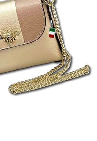 Sac à main en cuir vegan beige avec une chaîne dorée, orné d'un emblème d'abeille et d'un charm drapeau italien pour le détail.