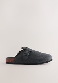 Sabot en feutre gris avec un bout arrondi, une bride ajustable et un accent en liège sur le talon. Semelle en caoutchouc plate pour le confort et la stabilité.