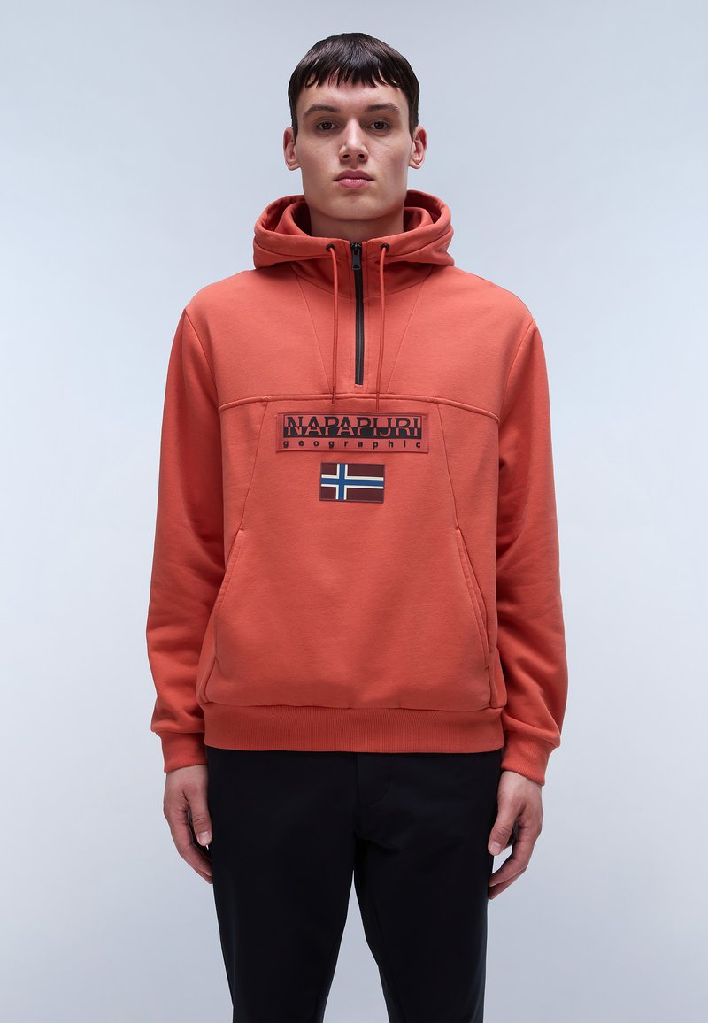 Felpa arancione con cappuccio e collo con zip, caratterizzata da una patch logo nera e un piccolo design a bandiera. Realizzata in materiale morbido e testurizzato.