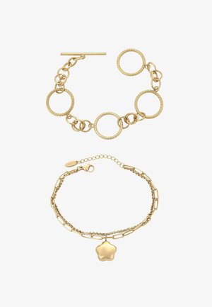 Gouden armband met schakels in elkaar grijpende cirkels en textuuraccenten. Een tweede armband heeft een stervormige hanger en verschillende schakels.