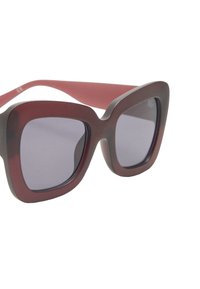 Okulari przeciwsłoneczne w kwadratowej oprawie z ciemnymi gradientowymi soczewkami. Oprawa ma połączenie koloru bordowego i szarego, z grubymi zausznikami.
