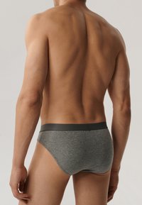 Szare bawełniane slipy z gładką, ciemnoszarym pasem w talii. Dopasowany krój podkreśla kształt. Miękka tekstura, minimalne detale i brak wzorów.
