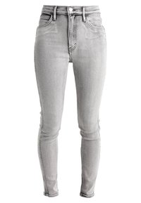 Jeans ajustados de denim gris claro, con una cintura alta, diseño clásico de cinco bolsillos y un ligero desvanecimiento en la parte delantera.