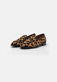 Luipaardprint loafers met een suede-achtige textuur, voorzien van een zwarte rand en een lage hak. Ontworpen voor eenvoudig aan- en uittrekken.