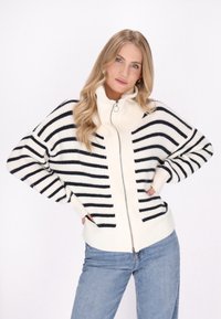 Maglione a righe con colletto alto, caratterizzato da spesse righe bianche e nere, una cerniera frontale completa e polsini e orlo a coste.