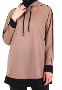 Vestido sudadera de color rosa pálido con detalles en negro, tejido texturizado, capucha con cordones y mangas en contraste. Diseño largo, corte holgado.