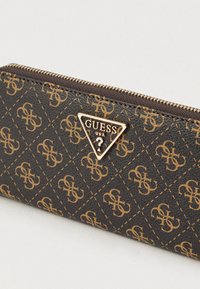 Portofel maro cu model și accent auriu. Dispune de închidere cu fermoar și petic triunghiular cu logo. Material texturat cu design în formă de diamant.