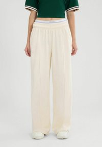 Crème kleurige wijde broeken met een elastische tailleband en zachte stof, voorzien van voorplooien voor extra detail en een rechte snit.