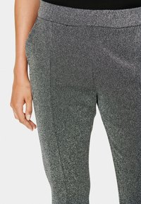 Szare, błyszczące spodnie z gładką fakturą i elastycznym pasem, z bocznymi kieszeniami i dopasowanym krojem.