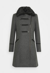 Abrigo de lana gris oscuro con cuello de piel sintética negra, cremallera diagonal, bandas decorativas negras con anillos plateados y mangas largas.