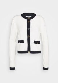 White cardigan with navy accents, featuring long sleeves, a round collar, two front pockets, and gold and silver buttons.