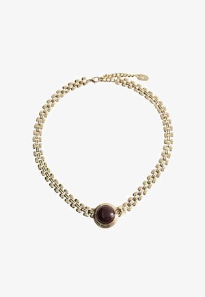 Collana in metallo dorato con un centro a gemma scura rotonda. La catena presenta un design intrecciato e strutturato con una chiusura regolabile.