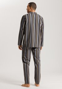 Conjunto de pijama a rayas en azul, negro y dorado, que incluye una camiseta de manga larga y pantalones a juego, fabricado en una tela suave con un ajuste holgado.