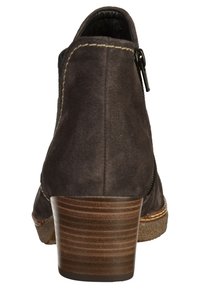Brązowe zamszowe botki za kostkę z brązową, warstwową podeszwą i zamkiem błyskawicznym z boku. Posiadają przeszycia oraz teksturowaną podeszwę dla lepszej przyczepności.