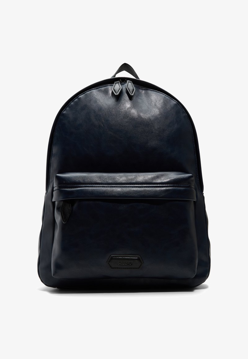 Granatowy skórzany plecak o gładkiej teksturze, zaokrąglonym kształcie, przedniej kieszeni na zamek oraz podwójnym zamku u góry. Posiada subtelną akcentację logo.