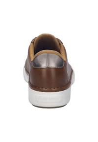 Baskets en cuir brun avec un accent argenté au talon, semelle blanche et intérieur doux. Détails cousus le long des bords.