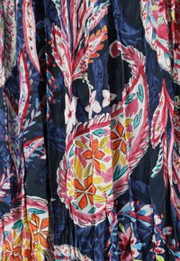 Material cu imprimeu floral, prezentând culori vibrante precum roz, galben și albastru, cu modele intricate și plisaje. Textură din bumbac, fundal bleumarin.