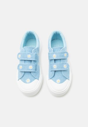 Zapatillas de niño pequeñas de color azul claro con suelas de goma blanca y patrones de margaritas en dos correas de velcro y en la zona de los dedos.