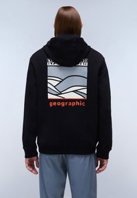 Svart hoodie med grafisk design som föreställer vågor i blått och vitt, samt ordet "geographic" i klar orange. Mjuk textur och avslappnad passform.