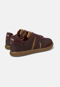 Adidași burdundii închis cu un material texturat, accente maro și o talpă din cauciuc. Dispun de un guler căptușit și un logo pe călcâi.