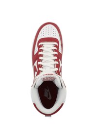 Tenisi Nike roșii și albi cu vârf perforat, șireturi plate și guler căptușit. Logo pe lateral și pe branț; textură de piele netedă.