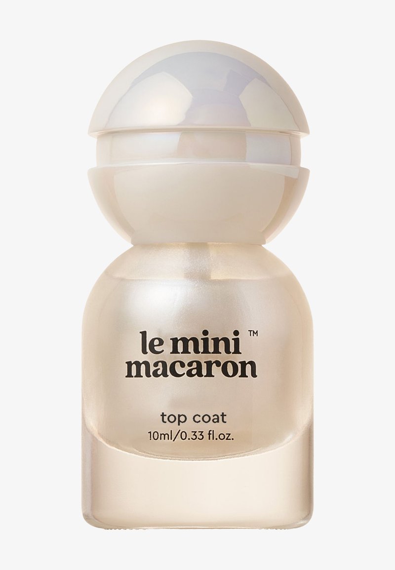 Top coat dans un flacon en verre circulaire avec une finition givrée. Le bouchon présente un design lisse et arrondi en blanc, avec le logo de la marque et les détails.