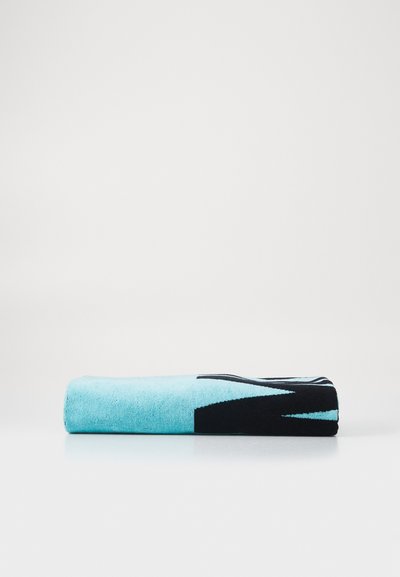Fleece blanket in turquoise and black. Features abstract patterns and a soft texture. Rolled and neatly presented against a white background.