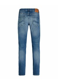 Modre ozke jeans hlače iz jeansa z bledenim vzorcem, dvema zadnjima žepoma in rjavo usnjeno etiketo blagovne znamke na pasu.