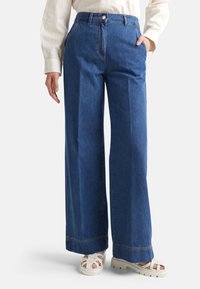 Jeans azules de pierna ancha hechos de mezclilla con cintura alta, que cuentan con bolsillos laterales, cierre de botón y detalles de costura en contraste.