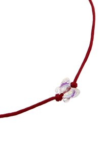 Collier en corde rouge avec une perle claire en forme de papillon au centre, mettant en avant un design délicat et un contraste de couleurs vif.