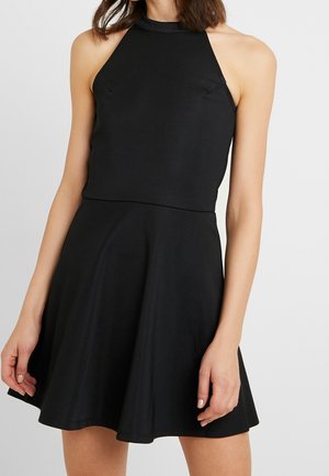 Robe noire à col halter en tissu lisse, corsage ajusté et jupe évasée. Présente des coutures discrètes et une finition soignée aux bords.