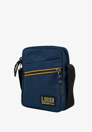Bolsa rectangular azul marino de textil con una cremallera amarilla, una placa con el logo y una correa ajustable. Presenta una superficie texturizada.