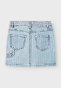 Jupe en denim bleu clair avec un design ajusté, deux poches arrière et des détails de couture visibles. Le tissu a une texture lisse.