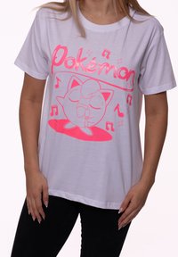 White T-shirt with pink Pokémon text and a pink outlined Jigglypuff character holding a microphone surrounded by music notes.