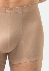 Boxer beige realizzati in tessuto strutturato con una cintura liscia sulla vita recante il nome del marchio "mey" in rilievo.
