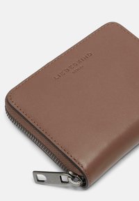 Bruine leren portemonnee met een gestreepte textuur, voorzien van een ritsclosure, metalen hardware en een reliëflogo detail aan de bovenrand.