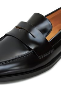 Zwarte leren loafers met een gladde afwerking, voorzien van een brede band over de wreef met een uitsnijdetail. Gestikte randen en een lage zool.