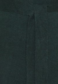 Dark green knit fabric with a soft texture, featuring a tied belt detail for closure and a simple, smooth surface without patterns.