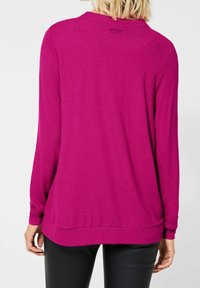 Maglione fucsia a maniche lunghe con una vestibilità rilassata, maniche a coste e orlo arrotondato. Tessuto morbido e branding minimale sul colletto.