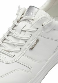 Baskets blanches en cuir lisse avec une finition texturée. Dotées de lacets intégrés, d'un accent logo en métal et d'une semelle rembourrée.